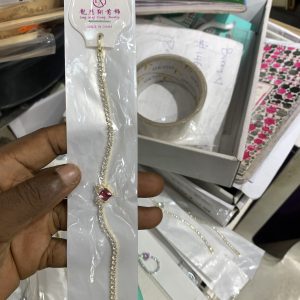 Gold bracelet with red stone